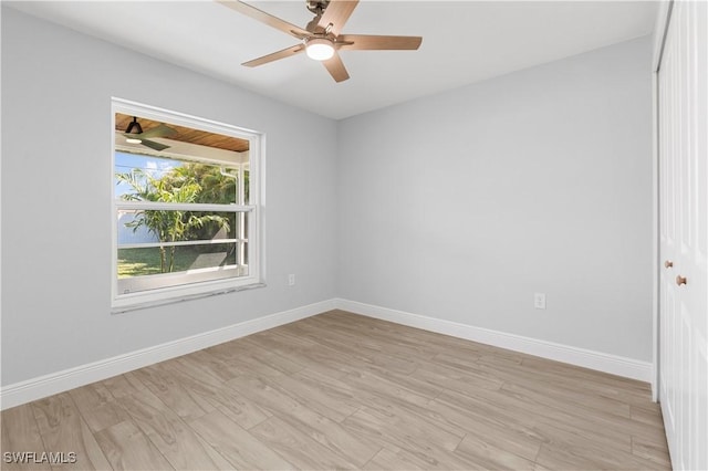 empty room with ceiling fan and light hardwood / wood-style flooring