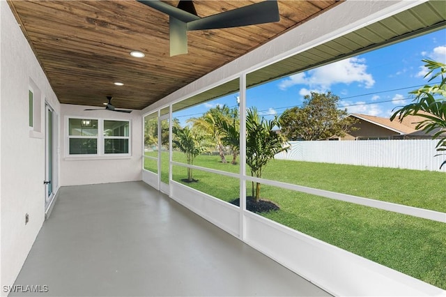 unfurnished sunroom with ceiling fan and wooden ceiling