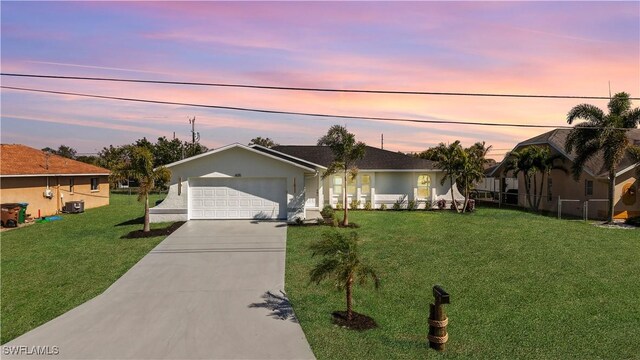 single story home with a front lawn, driveway, central AC, an attached garage, and stucco siding