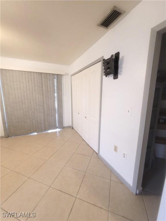 unfurnished bedroom featuring light tile patterned flooring and a closet