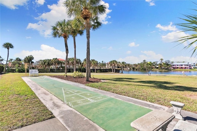 view of community with shuffleboard, a lawn, and a water view