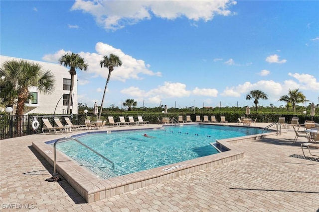 community pool with fence and a patio