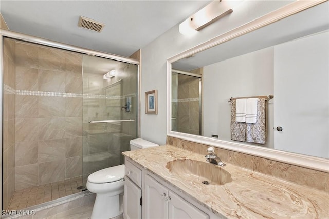 bathroom featuring a stall shower, visible vents, vanity, and toilet