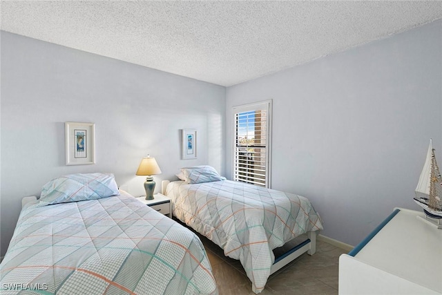 bedroom featuring a textured ceiling and baseboards