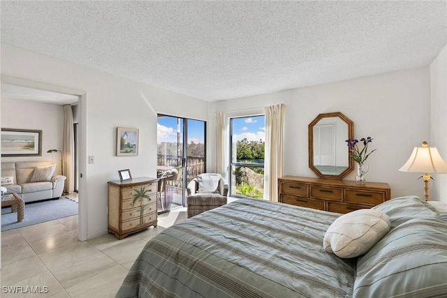 bedroom featuring light tile patterned floors, a textured ceiling, and access to exterior