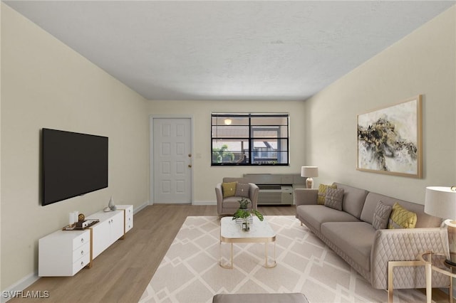 living room featuring a textured ceiling and light hardwood / wood-style floors