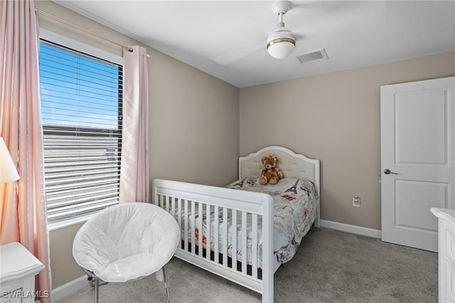 carpeted bedroom featuring a ceiling fan, visible vents, and baseboards