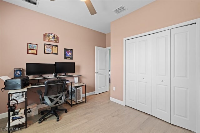 office space with light wood-style flooring, visible vents, ceiling fan, and baseboards