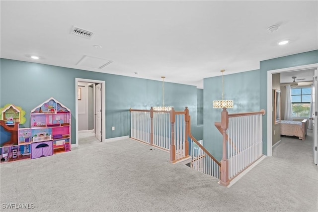 interior space with carpet floors, a notable chandelier, visible vents, an upstairs landing, and baseboards