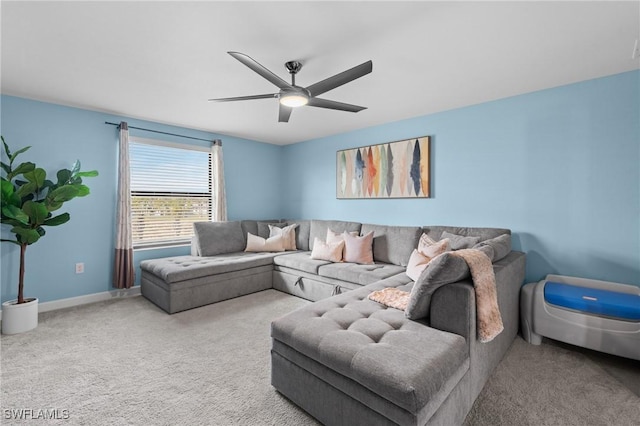 carpeted living area featuring a ceiling fan and baseboards