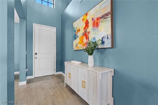 doorway featuring light wood-style flooring and baseboards