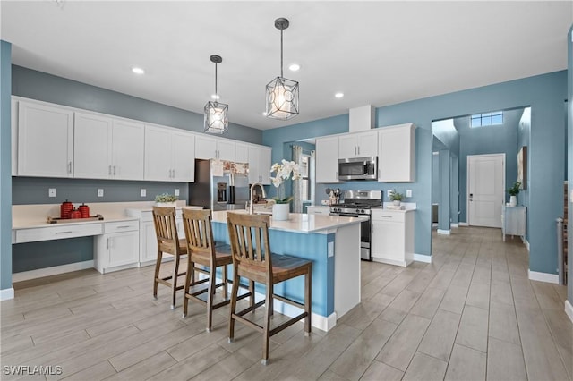 kitchen featuring stainless steel appliances, light countertops, wood tiled floor, white cabinets, and a sink