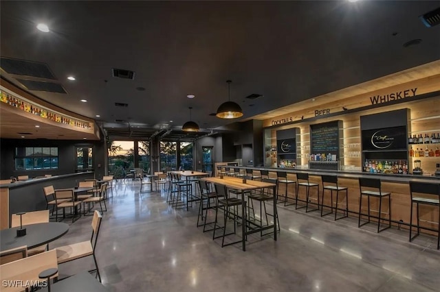 bar with a dry bar, concrete floors, and visible vents