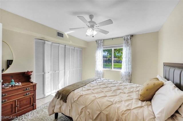 tiled bedroom with ceiling fan and a closet