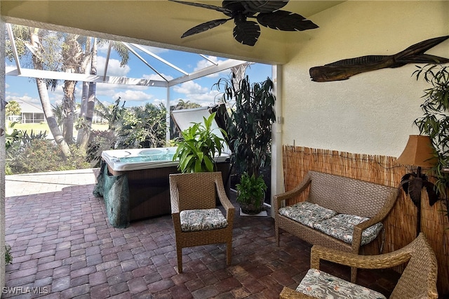 view of patio featuring glass enclosure and a hot tub