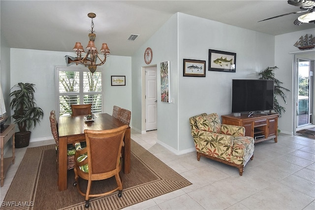 dining room with ceiling fan with notable chandelier, vaulted ceiling, and light tile patterned floors