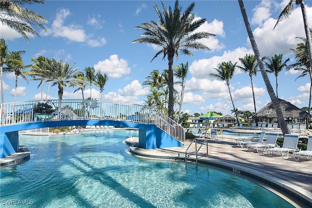 view of swimming pool with a water view and a patio area