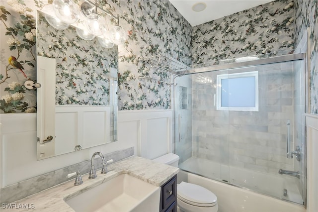 full bathroom featuring enclosed tub / shower combo, a wainscoted wall, toilet, and wallpapered walls