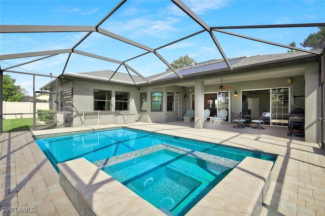 view of swimming pool with a pool with connected hot tub, area for grilling, a patio area, ceiling fan, and a lanai