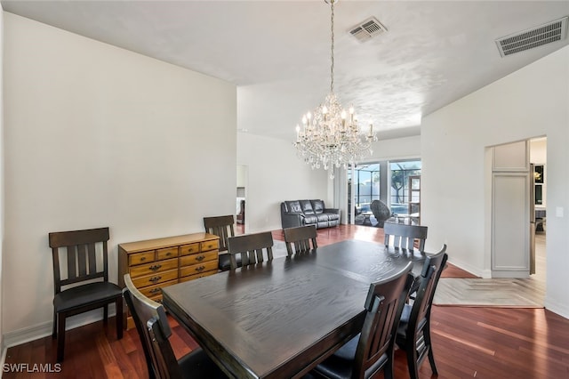 dining room with an inviting chandelier, baseboards, visible vents, and dark wood finished floors