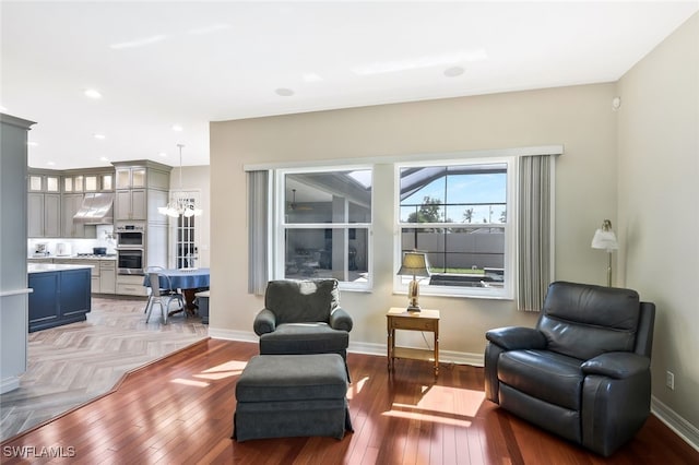 sitting room with hardwood / wood-style floors, an inviting chandelier, recessed lighting, and baseboards