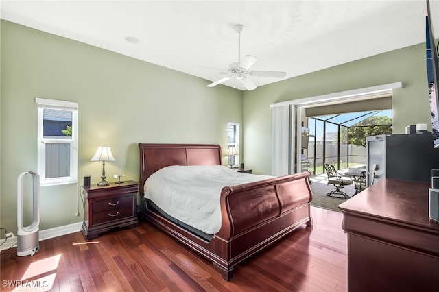 bedroom with dark wood-style floors, multiple windows, baseboards, and access to exterior