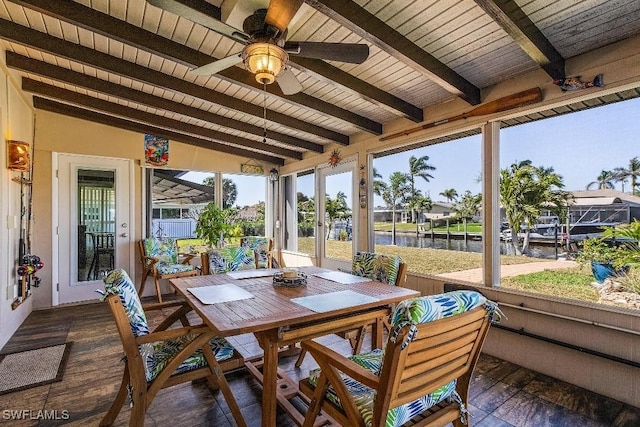 sunroom / solarium featuring a water view, wooden ceiling, ceiling fan, and lofted ceiling with beams