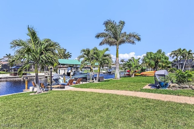 view of home's community featuring a dock, a water view, and a lawn