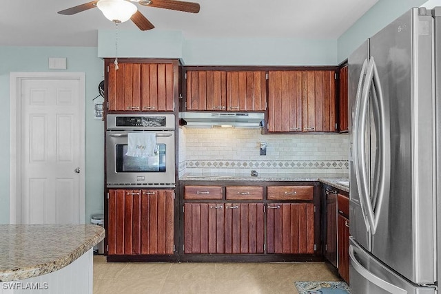 kitchen featuring a ceiling fan, backsplash, freestanding refrigerator, and under cabinet range hood