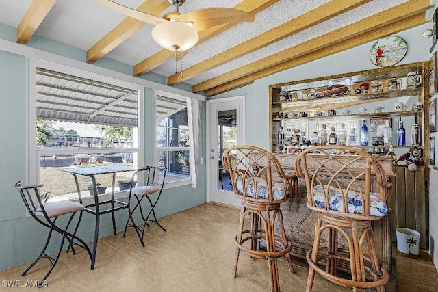 interior space with lofted ceiling with beams, a healthy amount of sunlight, a dry bar, and a sunroom