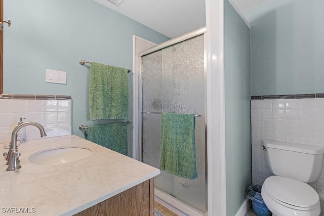 full bathroom with toilet, a stall shower, tile walls, and vanity