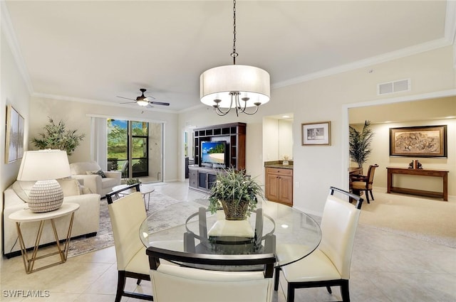 dining space featuring baseboards, visible vents, ceiling fan, crown molding, and light tile patterned flooring