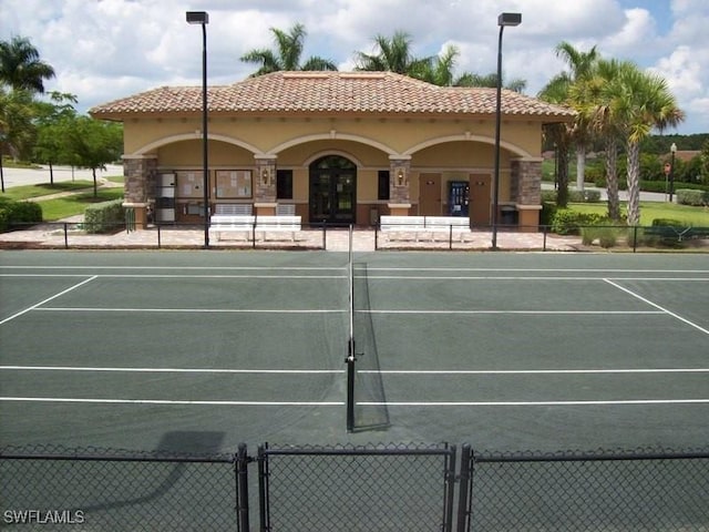 view of tennis court with french doors, fence, and a gate