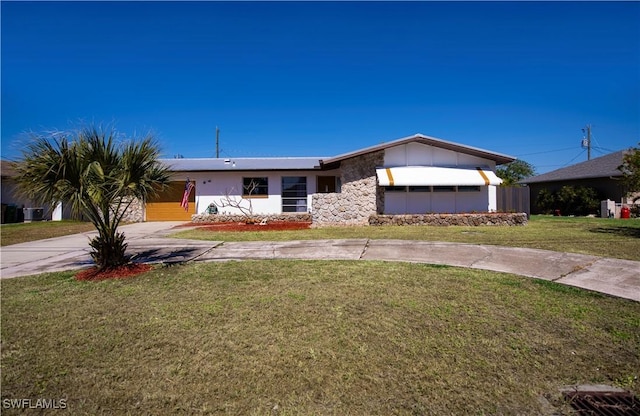 view of front of home featuring concrete driveway, stone siding, and a front yard