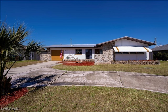 view of front facade with an attached garage, driveway, a front lawn, and stone siding