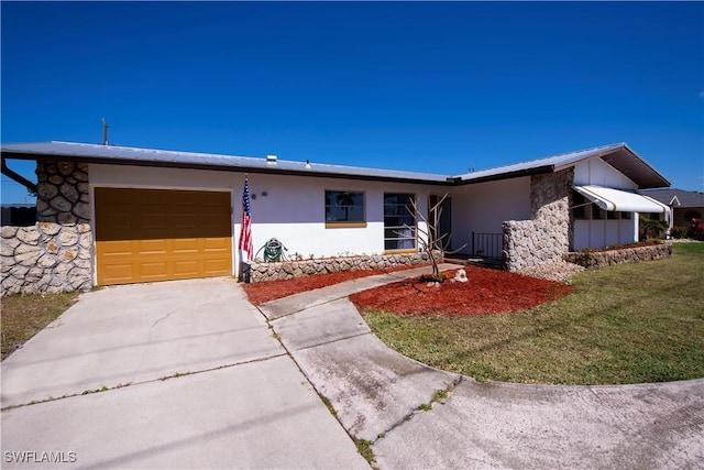 view of front of house with a garage, driveway, a front lawn, and stucco siding