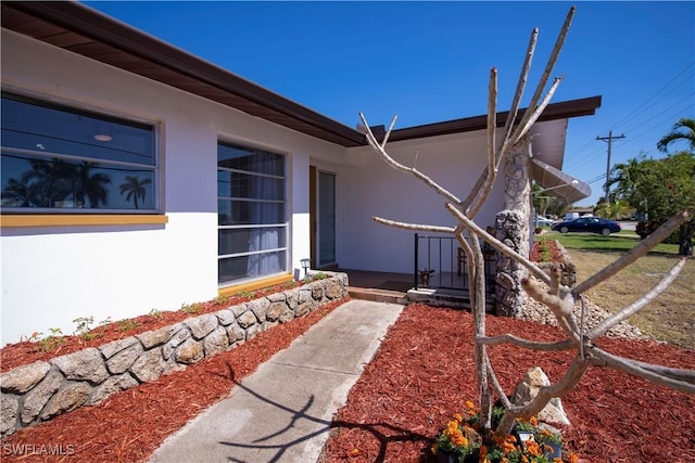 view of exterior entry featuring stucco siding