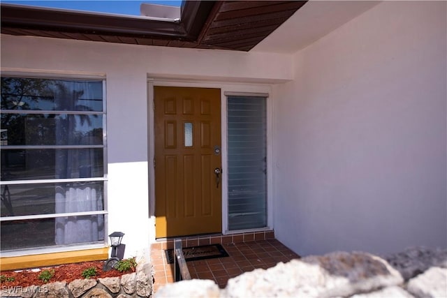 property entrance with stucco siding