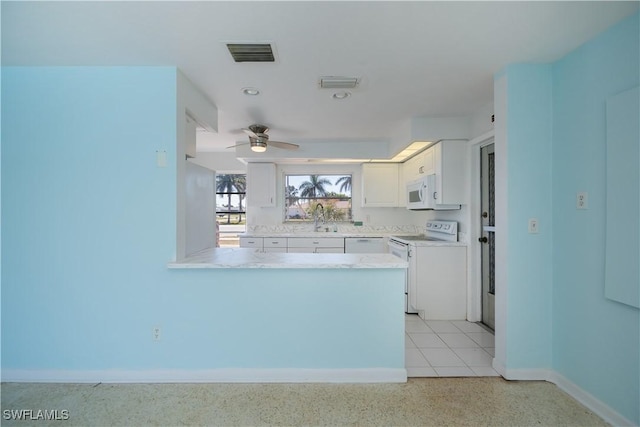 kitchen featuring visible vents, light countertops, white cabinets, white appliances, and a peninsula