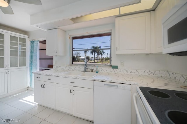 kitchen with white appliances, glass insert cabinets, and white cabinets