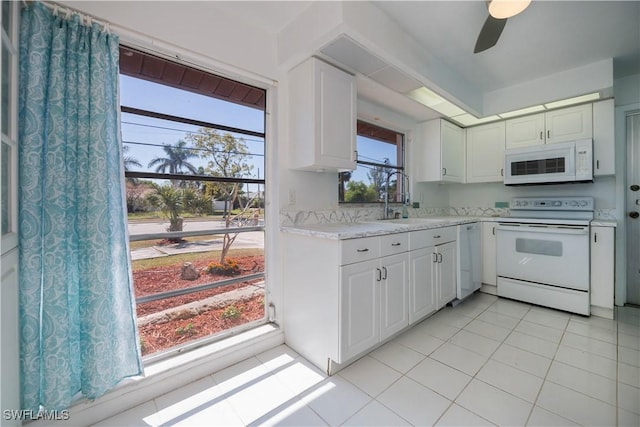 kitchen featuring light countertops, white appliances, white cabinets, and a sink