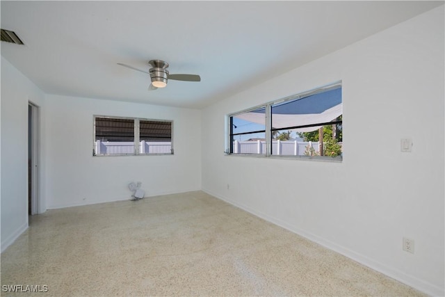 unfurnished room featuring light speckled floor, visible vents, and ceiling fan