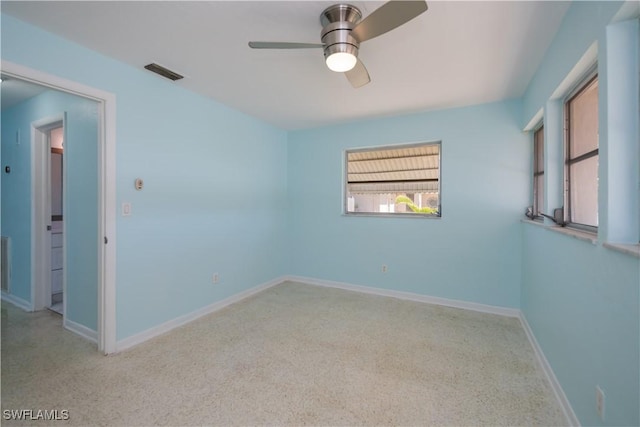 spare room with visible vents, ceiling fan, and baseboards