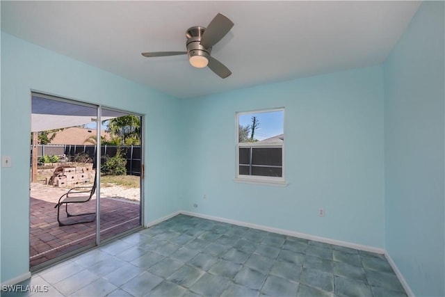 spare room featuring a ceiling fan, plenty of natural light, and baseboards