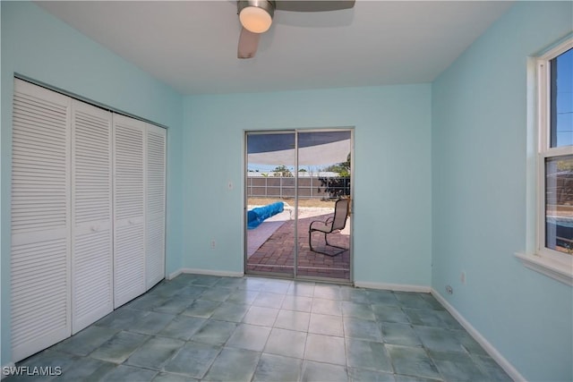 bedroom featuring access to exterior, light tile patterned floors, a closet, a ceiling fan, and baseboards