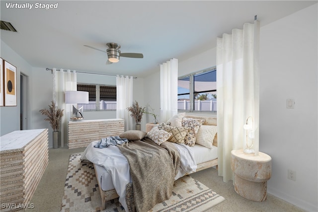 bedroom with visible vents, ceiling fan, and light carpet