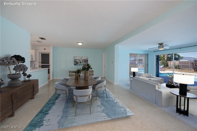 dining room featuring ceiling fan, baseboards, and light speckled floor