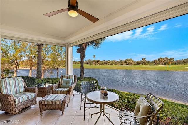 sunroom / solarium featuring ceiling fan and a water view