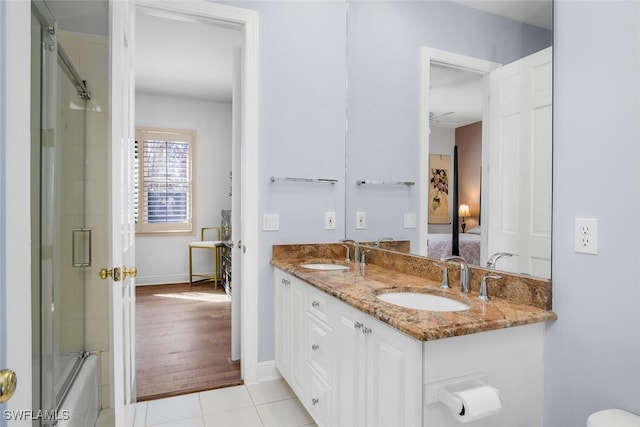 full bath featuring double vanity, connected bathroom, tile patterned floors, and a sink
