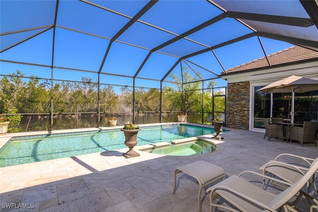 view of swimming pool featuring glass enclosure, a pool with connected hot tub, and a patio area